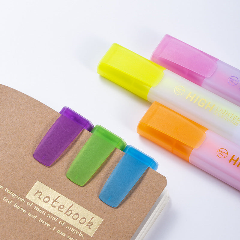 Highlighter caps next to a notebook