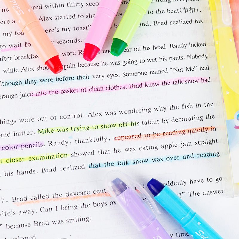 Gel highlighters marking lines on a printed book page